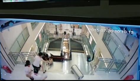 女子商场掉入电梯举起孩子